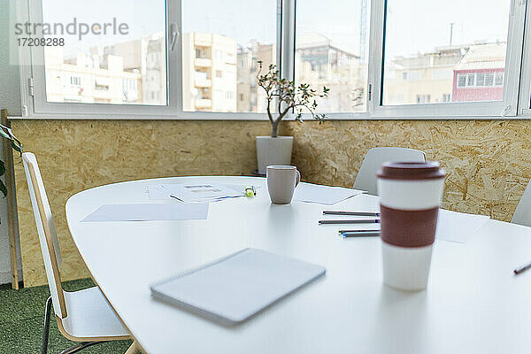 Leerer Konferenztisch mit Dokumenten und Kaffeetassen im Büro