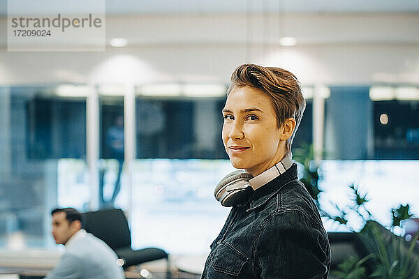 Porträt der kurzen Haare Geschäftsfrau mit Kopfhörer um den Hals im Büro