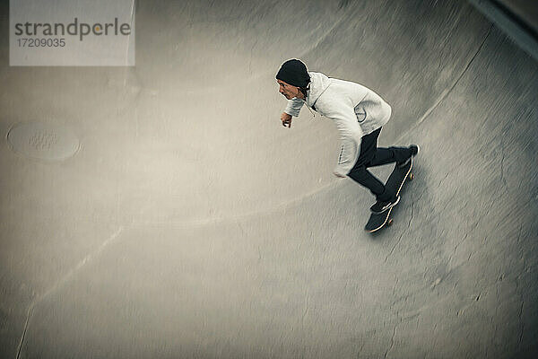 Mittlerer Erwachsener Mann beim Skaten im Skateboard-Park