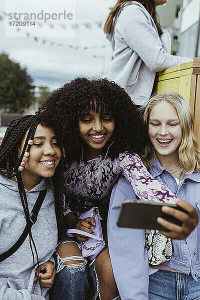 Glückliche weibliche Freunde nehmen Selfie auf intelligente im Freien