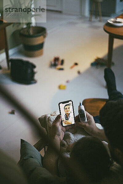 Hohe Winkel Ansicht von Vater und Tochter  die Online-Beratung durch Smartphone zu Hause