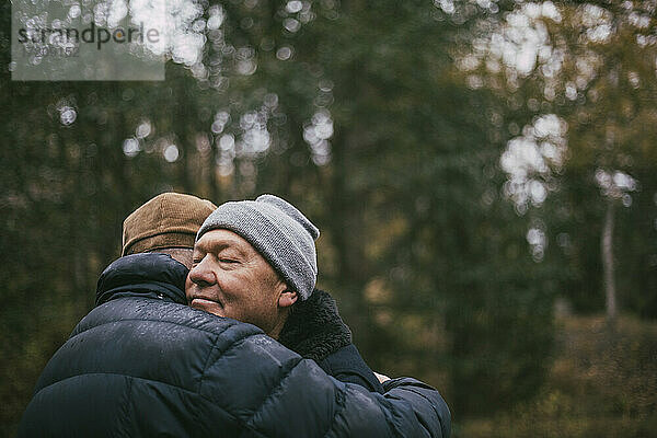 Homosexuelles Paar umarmt sich gegenseitig im Wald