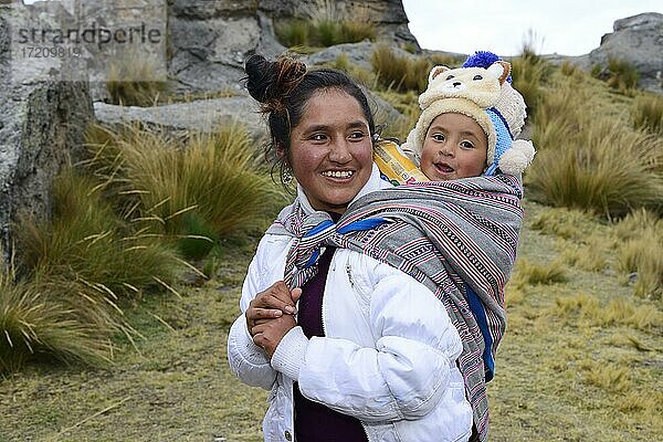 Lächelnde indigene Frau mit Kleinkind am Rücken  Provinz Junín  Peru  Südamerika