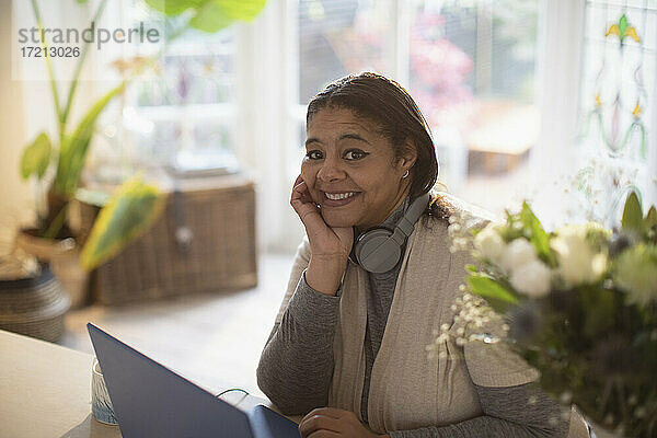Porträt glückliche Frau arbeitet von zu Hause aus am Laptop