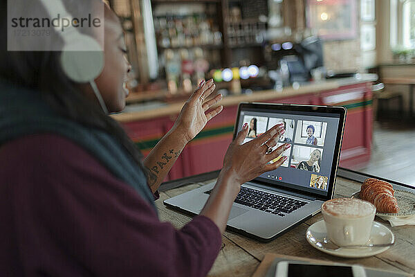 Frau Videokonferenz mit Kollegen am Laptop auf Cafe Tisch