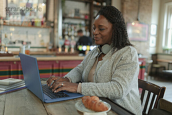 Frau arbeitet am Laptop im Café
