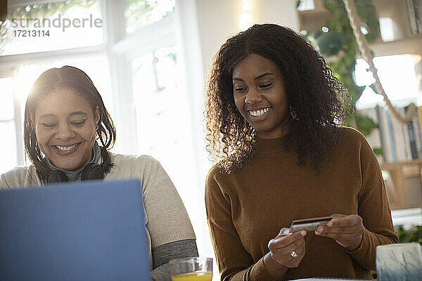 Glückliche Mutter und Tochter beim Online-Shopping am Laptop