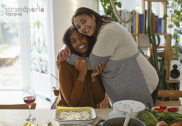 Porträt glücklich Mutter und Tochter umarmen und machen Lasagne