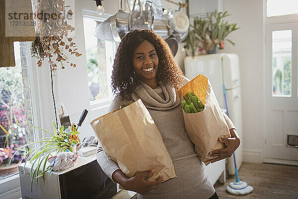 Porträt glückliche Frau mit Lebensmitteln in der Küche