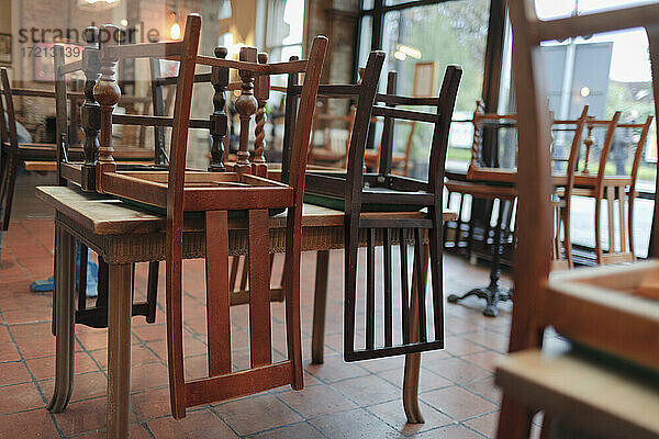 Holzstühle umgedreht auf Tischen in leerem Restaurant