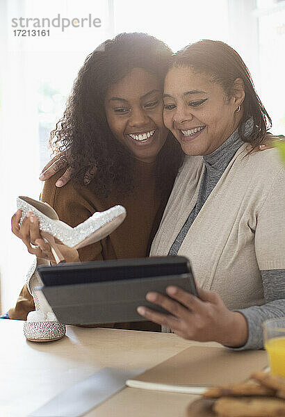 Glückliche Mutter und Tochter mit Hochzeit Schuhe und digitale Tablette