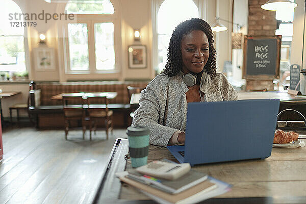 Frau arbeitet am Laptop auf dem Tisch im Cafe