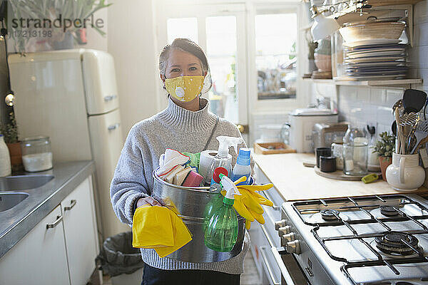 Porträt selbstbewusste Frau in Gesichtsmaske mit Küchenreinigungsmitteln