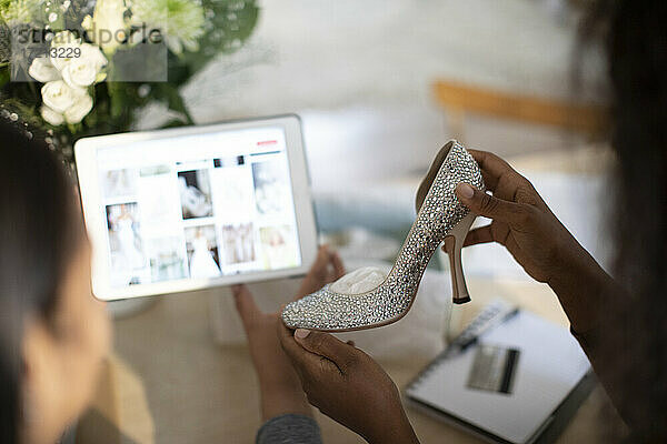Frauen mit Hochzeitsschuhen beim Einkaufen von Ideen auf einem digitalen Tablet