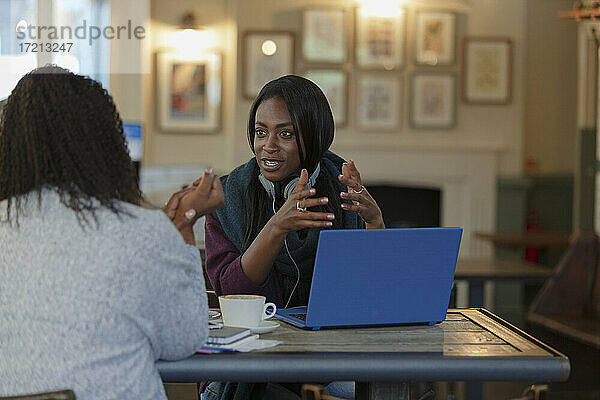 Geschäftsfrauen im Gespräch am Laptop im Cafe