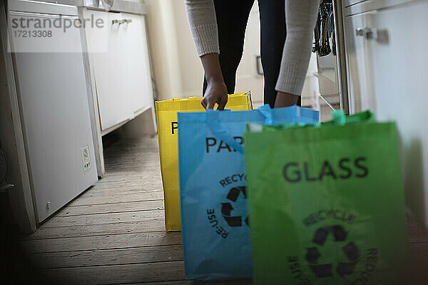 Frau sortiert in der Küche Recycling in Säcke