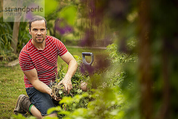 Porträt zuversichtlich Mann Ernte Gemüse im Garten