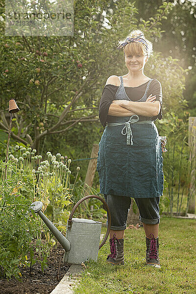 Portrait selbstbewusste Frau mit Gießkanne im Sommergarten