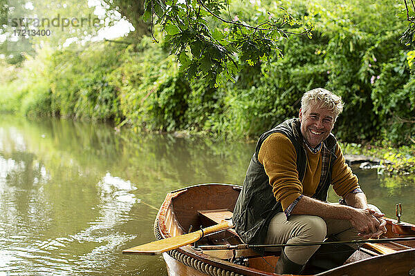 Porträt glücklicher Mann Fliegenfischen in Boot auf Fluss
