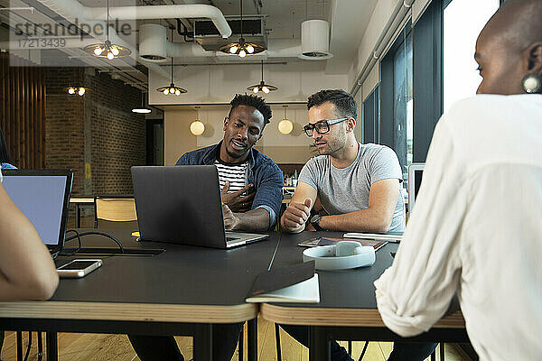 Geschäftsleute treffen sich am Laptop im Büro