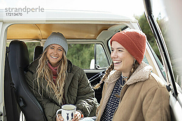 Glückliche junge Frauen Freunde mit Kaffee in Camper van Türöffnung