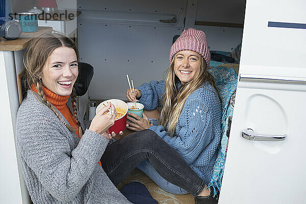 Porträt glücklich junge Frauen Freunde warten Instant-Nudeln in van
