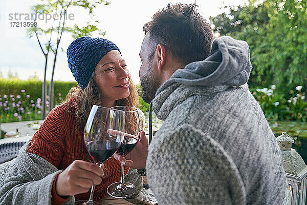 Zärtliches romantisches Paar trinkt Rotwein auf der Veranda
