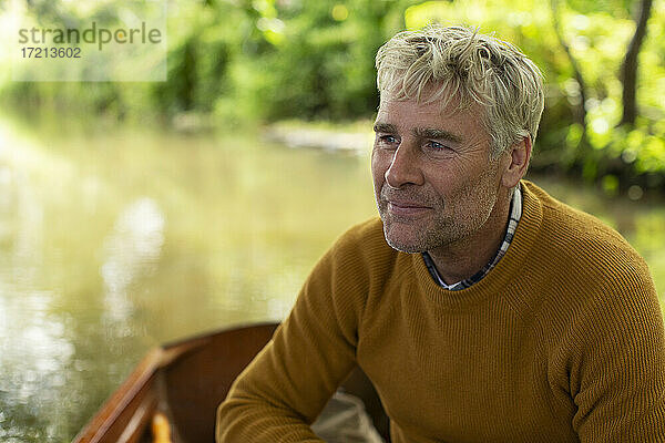 Glücklicher Mann in Boot auf Fluss