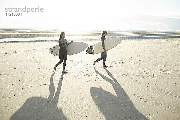 Junge weibliche Surfer mit Surfbrettern auf sonnigen Sommerstrand