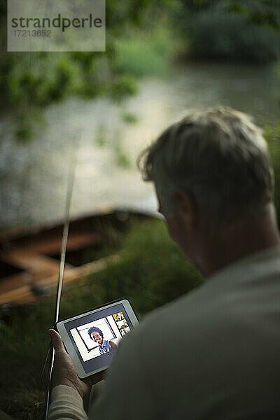 Mann Fliegenfischen und Video-Chat mit digitalem Tablet