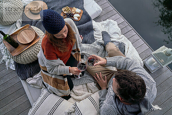 Ehepaar genießt Wein und Käse auf Terrassen-Kissen