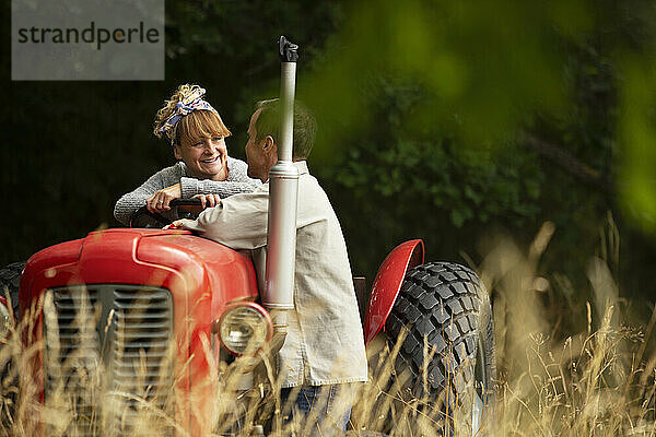 Glückliches Paar am Traktor im Obstgarten