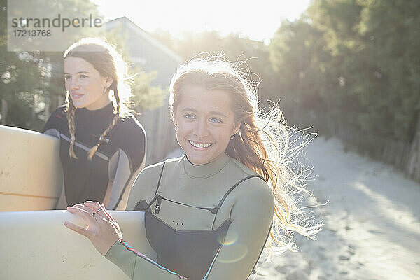 Porträt glücklich junge weibliche Surfer auf sonnigen Strand Weg