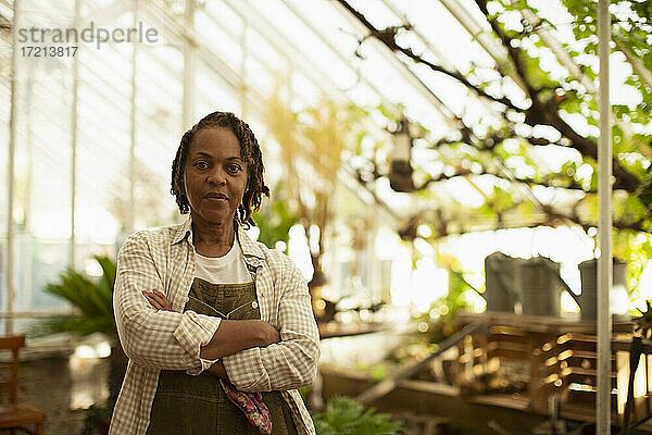 Porträt selbstbewusste Gartenladenbesitzerin im Gewächshaus