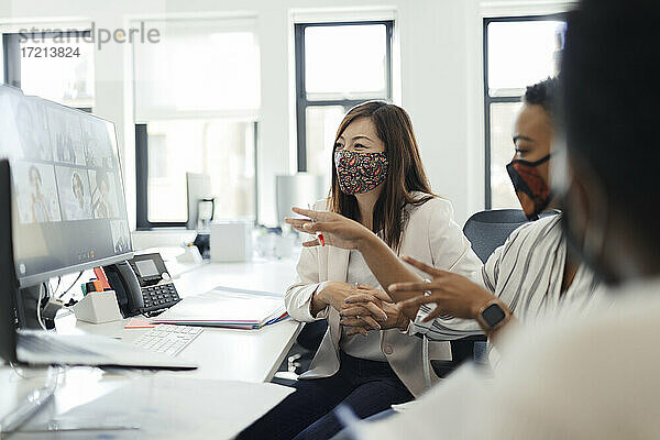 Geschäftsleute in Gesichtsmasken Videokonferenzen am Computer im Büro
