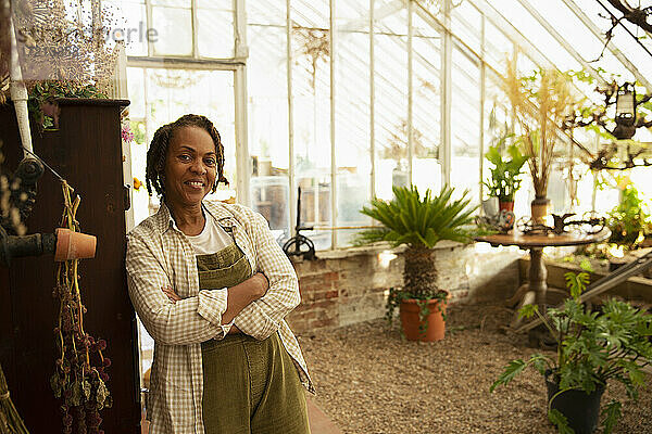 Porträt selbstbewusste Gartenladenbesitzerin im Gewächshaus