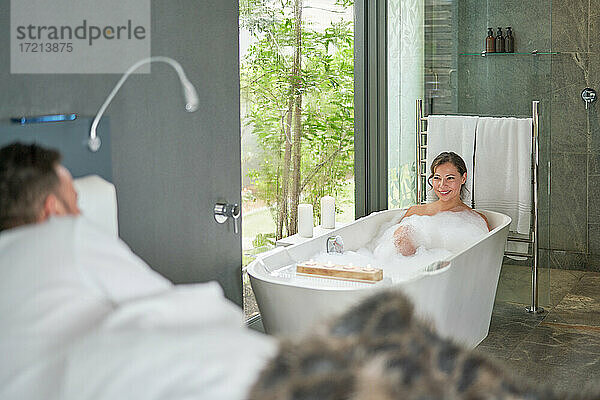 Glückliches Paar entspannt sich in einem luxuriösen Hotelzimmer mit Whirlpool