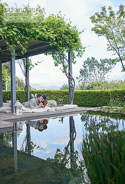 Zärtliches Paar entspannt auf Kissen auf der Terrasse eines Luxushotels