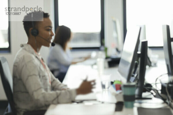 Geschäftsfrau im Headset arbeitet am Computer im Call-Center-Büro