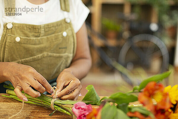 Close up weiblichen Florist arrangieren Blumenstrauß im Laden