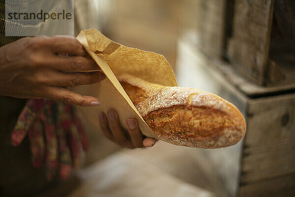 Close up Bäckerin hält frisch gebackenes Baguette-Brot