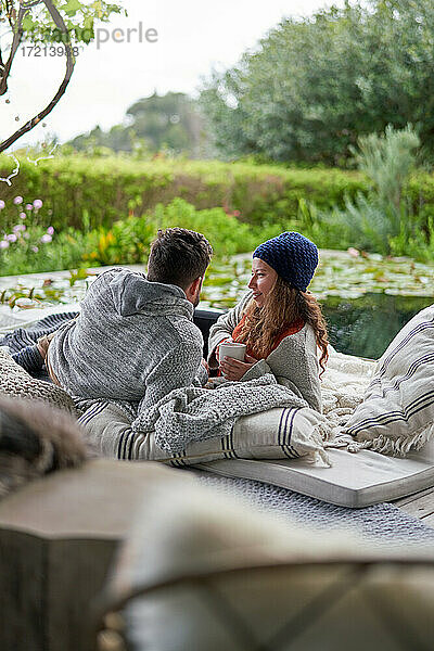 Paar entspannt sich mit Kaffee auf Luxus-Terrassen-Kissen