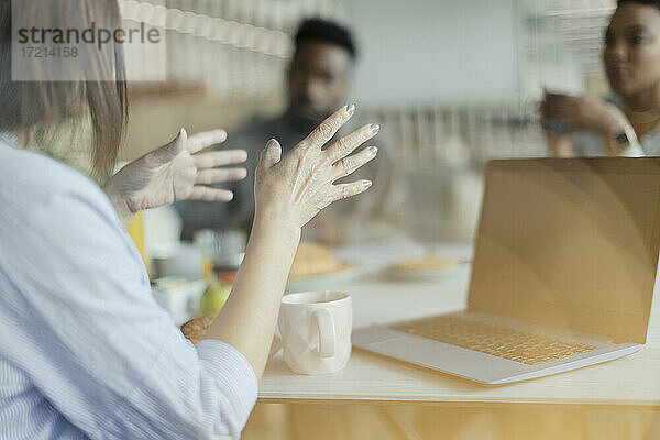 Geschäftsfrau im Gespräch und Gesten am Laptop im Büro Sitzung