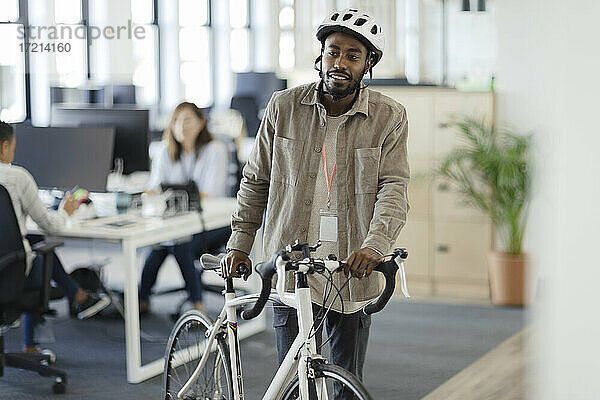 Geschäftsmann zu Fuß Fahrrad im Büro