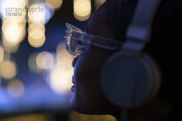 Close up junge Frau in funky Brille und Kopfhörer Blick auf Lichter