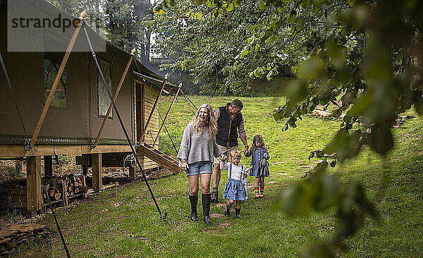 Familie zu Fuß außerhalb Hütte im Wald