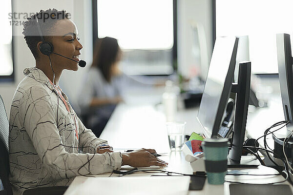 Geschäftsfrau mit Headset arbeitet am Computer im Callcenter-Büro