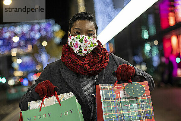 Porträt glückliche junge Frau in Weihnachten Gesichtsmasken Einkaufen in der Nacht