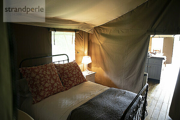 Bett und Lampe in Luxus-Campingjurte