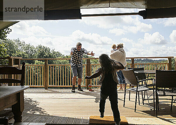 Glückliche Tochter läuft zu Vater auf sonnigen Sommer Kabine Balkon